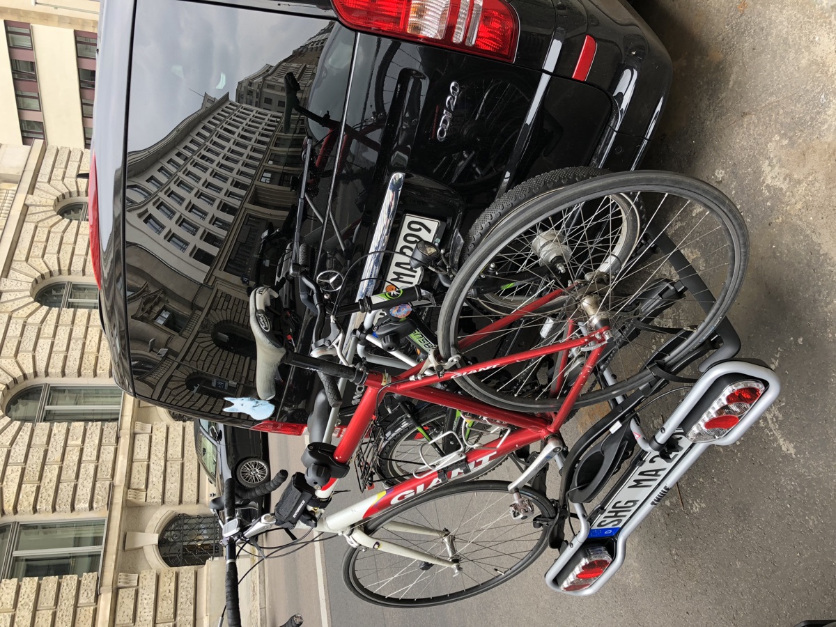 Two bicycles mounted on the back of a city vehicle